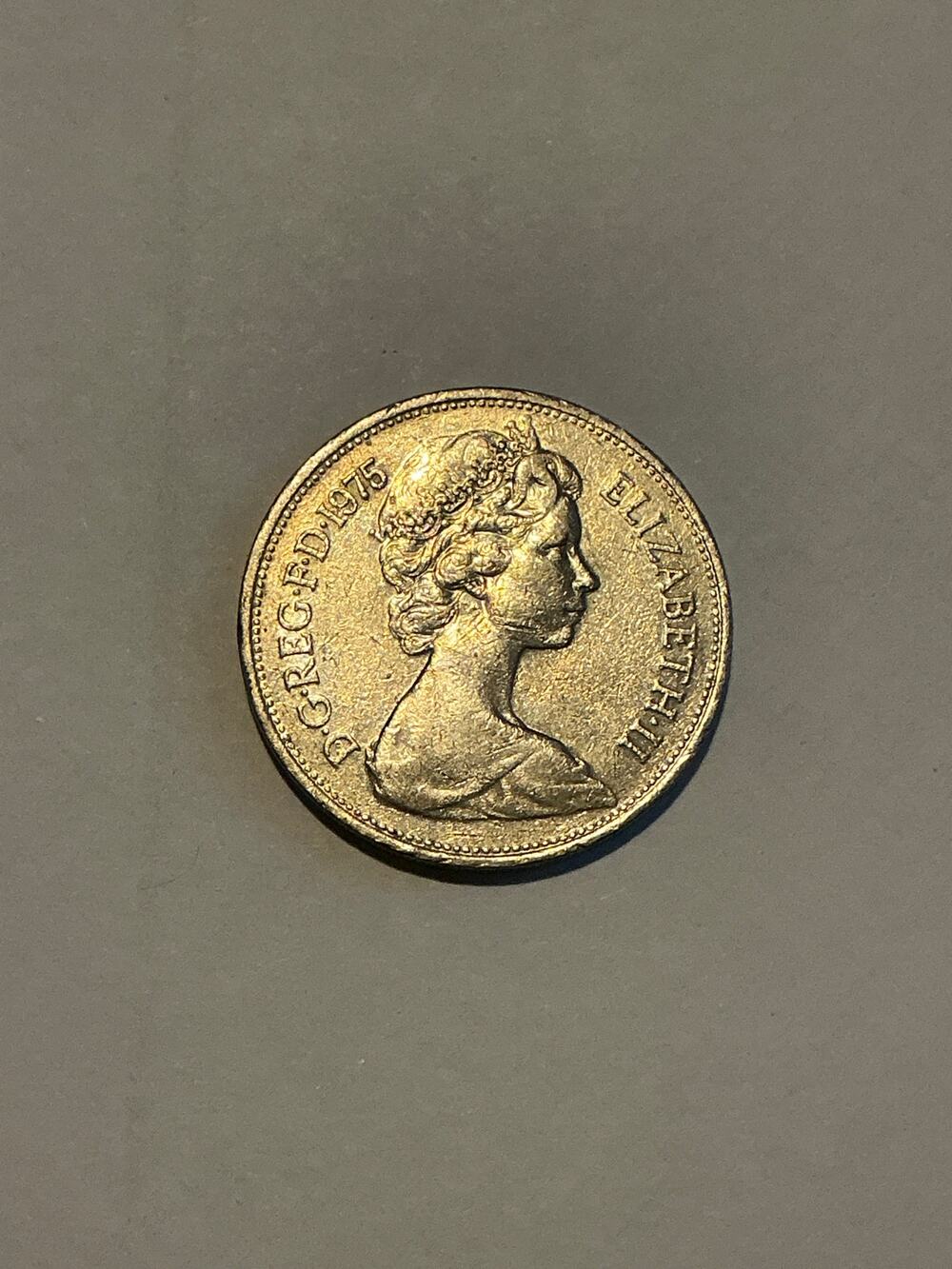 1975 British one-pound coin featuring a portrait of Queen Elizabeth II.